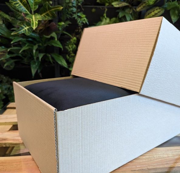 Photo of a corrugated cardboard box half open with blue material inside